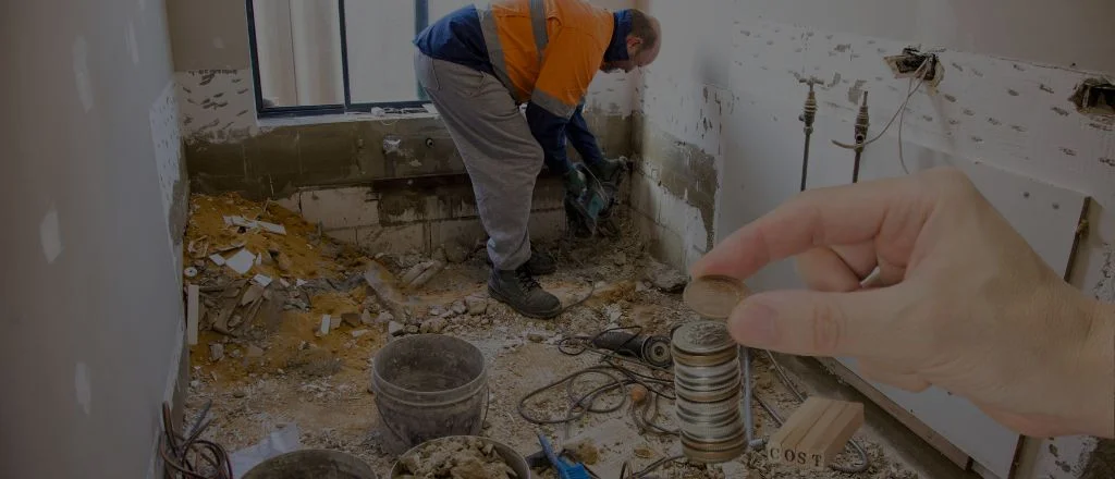 Worker removing bathroom tiles with a drill — overlaid with coins to represent renovation costs in Australia, 2025